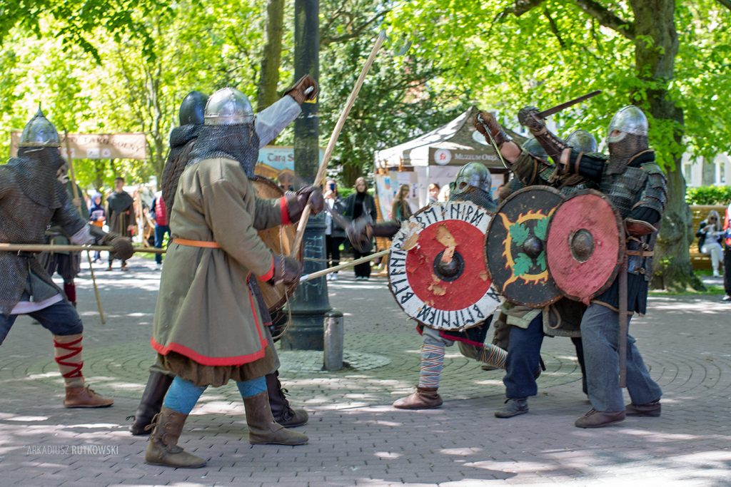 Uczestnicy w średniowiecznych strojach prezentujący swoje umiejętności.